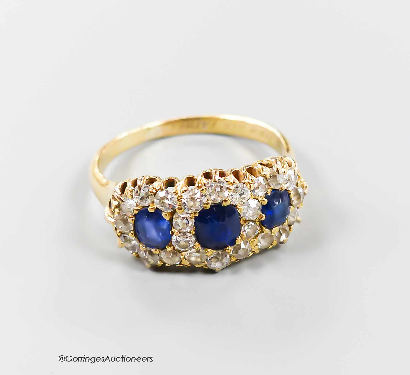 A late Victorian yellow metal, sapphire and diamond set triple cluster ring, with shank inscription, size M, gross weight 3.7 grams.